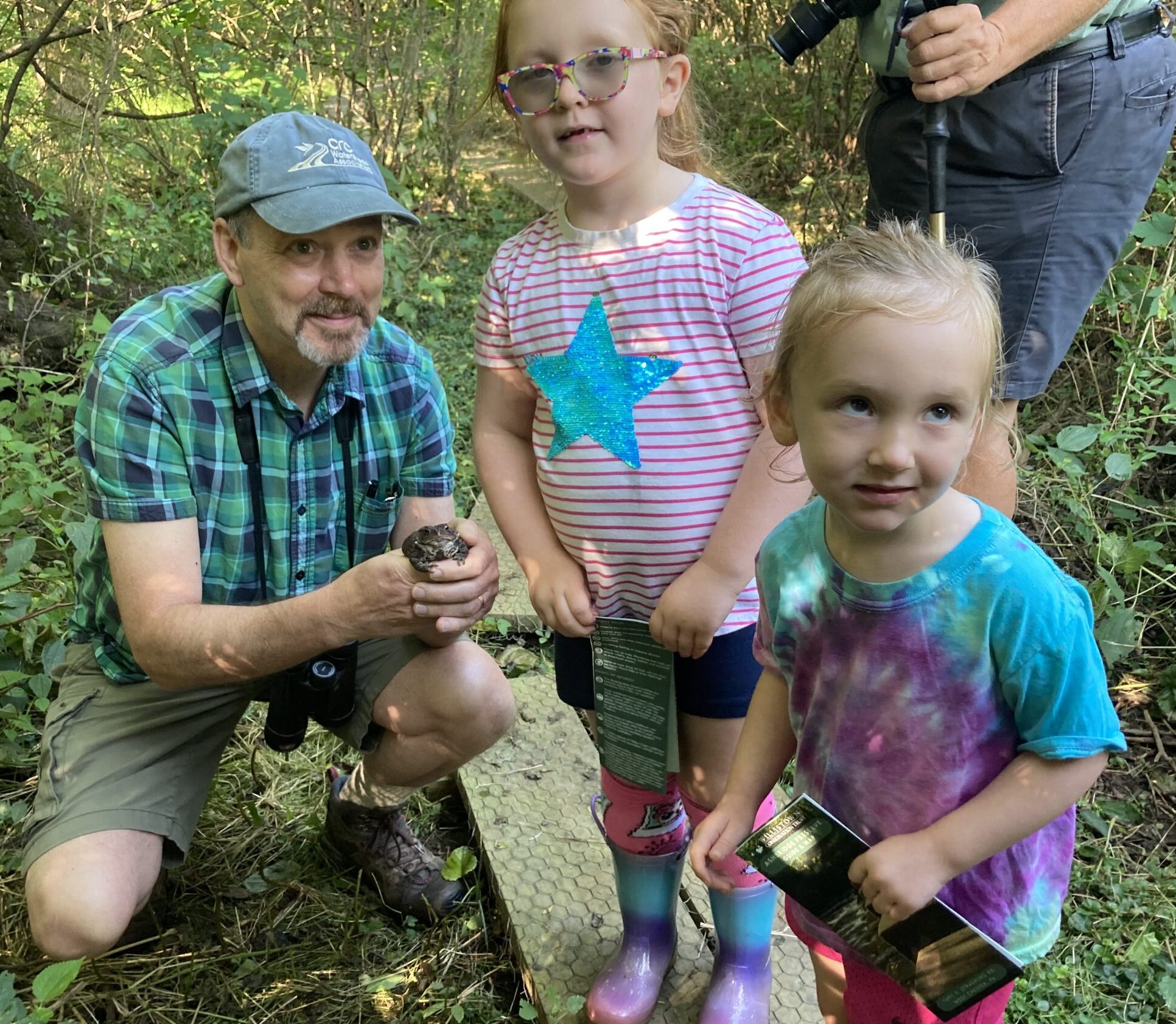 2 children with a hike leader holding a frog